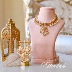 A dazzling fusion of tradition and modern allure - perfect for this festive season to pop some color in your radiant celebrations! Elevate your style with this enchanting ensemble that seamlessly blends the richness of nauratan stones with the classic charm of faux pearls. The set includes a necklace, a maang teekah and a pair of matching earrings. Approximate earrings length is 3.2". Gold-plated on high-quality brass as the base metal. Made by order. Kindly allow 5-7 weeks for the delivery of t