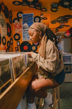 a woman is looking at records on the wall