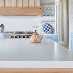 a tea kettle sitting on top of a kitchen counter next to a stove and oven