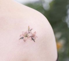 a woman's shoulder with a flower tattoo on the left side of her body