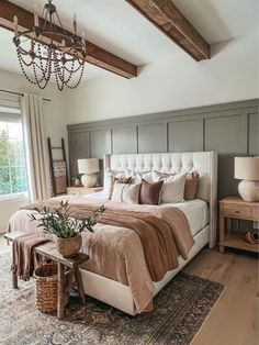 a bedroom with a large bed and chandelier in the corner, along with a rug on the floor