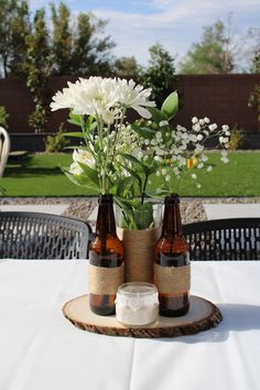 three bottles with flowers in them sitting on a table