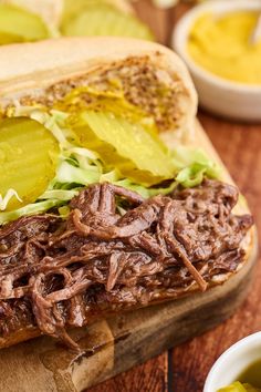 a sandwich with meat and lettuce on a cutting board