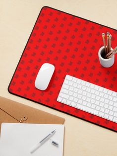 a desk with a keyboard, mouse and pen on it next to a notepad