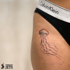 a woman's stomach with a tattoo of a jellyfish