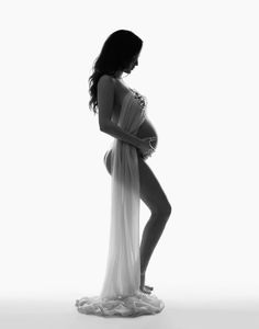 a pregnant woman standing in front of a white background