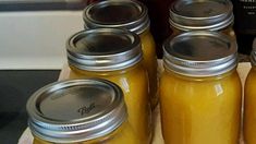 several jars filled with yellow liquid sitting on top of a counter