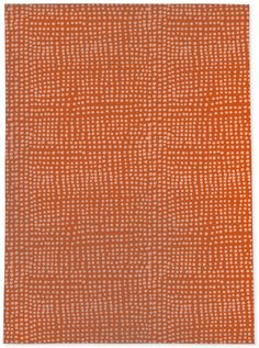 an orange rug with white dots on it