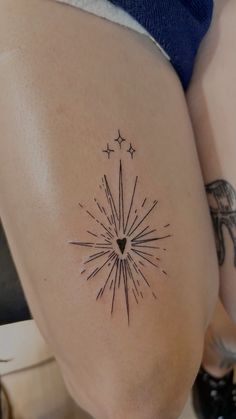 a woman's thigh with a star tattoo on the back of her leg and an arrow in the middle