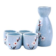 four blue vases with white flowers painted on them and one has red berries in it