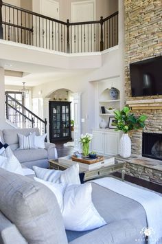 a living room filled with furniture and a flat screen tv mounted on the wall above a fireplace