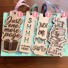 wooden bookmarks with different sayings on them sitting on a table next to some ribbons