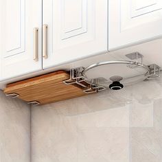 a kitchen with white cabinets and wooden cutting board on the wall above the counter top