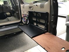 the back end of a van with its door open and an entertainment center in it