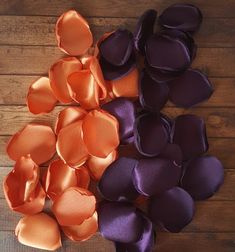 several orange and purple satin flowers on a wooden surface