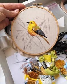 a person is working on some art work with thread and scissors in front of it