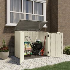 a white storage shed with tools in it