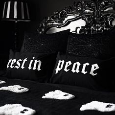 two black and white pillows with the word rest in peace written on them sitting on a bed