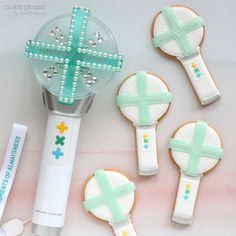 decorated cookies and cookie cutters are arranged on a white table with pastel colors