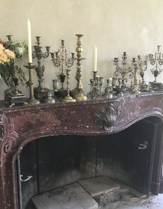 an old fireplace with many candles on it