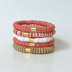 This burnt orange and white heishi disc bracelet stack is perfect for game day and wearing your school colors! 🧡 This stack makes a great birthday or graduation gift! The stack of 5 bracelets contains: 2 - Burnt Orange Heishi disc bracelets 1 - White Heishi disc bracelet 1 - Burnt Orange, White, and Gold Heishi disc bracelet  1 - Telluride Wooden Disc Bracelet  All bracelets are available individually or sold together as a set of 5.  Bracelets are handmade on strong stretch cord and approximate Adjustable White Stacked Stretch Bracelet, White Adjustable Stacked Stretch Bracelet, White Stacked Stretch Bracelet As Gift, White Stacked Stretch Bracelet Gift, White Stacked Beaded Bracelets, White Stacked Casual Bracelets, Casual White Stacked Bracelets, White Stacked Beaded Bracelets For The Beach, Bracelets Heishi