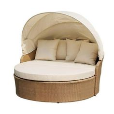 an outdoor day bed with white pillows on it