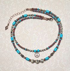 Boho style layered necklace created using Dalmation Jasper gemstone beads, turquoise Howlite stone beads, red Japanese Picasso seed beads, tiny turquoise seed beads, antique copper accents throughout, and an antique copper peace sign charm.  The longest strand measures approximately 17", and the shortest strand measures approximately 15-1/2". Adding an additional 2", the extender chain is finished with a small copper charm.  The peace sign charm measures 1/2" x 1/2". For matching earrings, click on the link below: https://www.etsy.com/listing/1779229641/copper-peace-sign-earrings-gemstone-and?click_key=284c28ea52e49b3ffa4e26bbd353bff23e91a64a%3A1779229641&click_sum=1d1d9a2e&ref=shop_home_active_1&frs=1 Thank you for shopping with The Lucie Collection! Bohemian Jewelry With Tiny Beads For Layering, Bohemian Double Strand Jewelry With Tiny Beads, Turquoise Hippie Necklace For Jewelry Making, Hippie Turquoise Necklaces For Jewelry Making, Adjustable Multi-strand Bohemian Turquoise Necklace, Bohemian Multi-strand Necklace With Spacer Beads, Bohemian Multi-strand Adjustable Turquoise Necklace, Bohemian Gemstone Beaded Necklaces For Layering, Bohemian Gemstone Beads Necklace For Layering