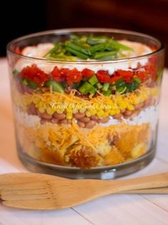 a layered salad in a glass dish on a table