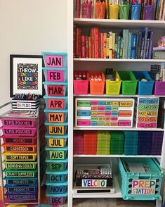 a book shelf filled with lots of books and colorful bins next to each other