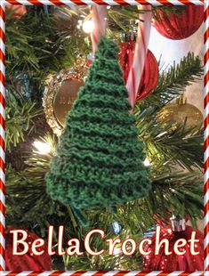 a crocheted christmas tree ornament hanging from a christmas tree with candy canes