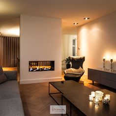 a living room filled with furniture and a fire place next to a wall mounted tv