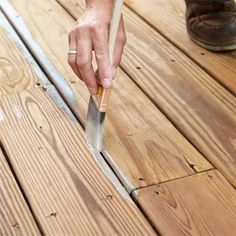 a person holding a knife on top of a wooden floor