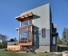 a modern house in the middle of a grassy area