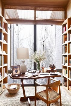 a room with many bookshelves and a table in the middle filled with items