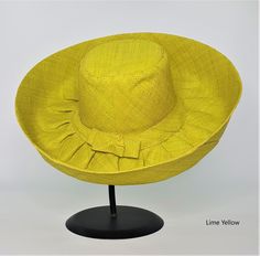 Raffia Curve Brim Hat in Lime Yellow Colour      These amazing hats are dyed, loomed and sewn all by hand. Made in Madagascar. The hats are great sun protection having 2 layers on the brim and around the crown, 3 layers for crown top. Hats can be rolled up for packing in handbag or suitcase.       Measures 12cm brim.      Ethical, eco-friendly, sustainable.      About Raffia      Raffia is native to Madagascar and a sustainable resource to the country. Collectors go deep in the island to harvest Yellow Wide Brim Straw Hat In Toquilla Straw, Yellow Wide Brim Toquilla Straw Hat, Handmade Yellow Wide Brim Straw Hat, Yellow Straw Hat With Curved Brim, Yellow Brimmed Straw Hat, Yellow Straw Sun Hat With Short Brim, Yellow Wide Brim Sun Hat For Kentucky Derby, Adjustable Sinamay Straw Hat For Beach, Adjustable Sinamay Sun Hat For Summer