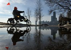 a man riding a bike on top of a puddle