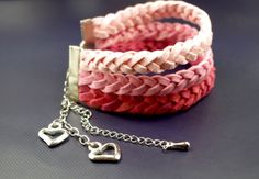 a pink and white bracelet with two hearts on it