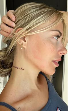 a woman with a small tattoo on her neck