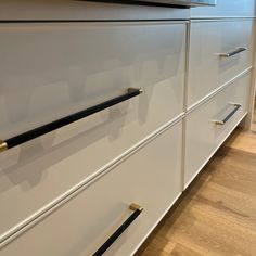 a kitchen with white cabinets and black handles on the drawers is seen in this image