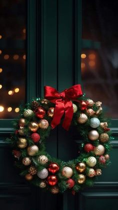 a green door with a christmas wreath and red bow hanging on it's side