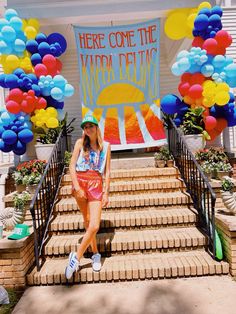 a woman sitting on the steps in front of a sign that says here come the karra deto