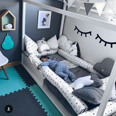 a child is sleeping in his bed with pillows