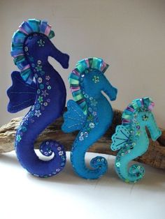 three seahorses sitting on top of a piece of driftwood next to each other