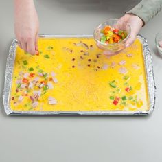 a person scooping food into a bowl on top of a metal baking sheet with other ingredients