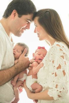 a man and woman are holding their babies