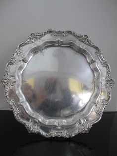 an ornate silver plate on a black table