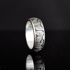 Behold the mesmerizing symbol of eternal love and romance: The Curved Silver Wedding Band. Crafted with meticulous precision, this slender band, 0.29 inches wide, gracefully adorns your finger. Its elegant design showcases delicate embossed petals entwined together like souls in an eternal embrace. Its oxidized matte finish symbolizes the purity and strength of love, while its curved shape represents the journey of two entwined hearts. This mesmerizing ring serves as a timeless reminder of the p Etched Promise Ring Jewelry, Symbolic Wedding Jewelry With Intricate Design, Symbolic Wedding Rings With Decorative Band, White Gold Etched Promise Ring, Symbolic Engraved Wedding Ring, Symbolic Wedding Engraved Ring, Symbolic Hallmarked Wedding Rings, Symbolic Wedding Rings Hallmarked, Etched Round Promise Ring