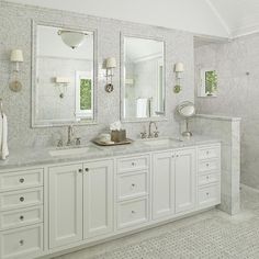 a white bathroom with double sinks and mirrors