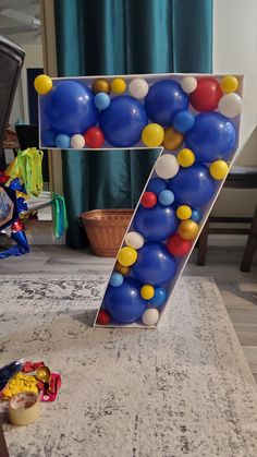 the letter z is made out of balloons and sits on top of a rug in front of a window