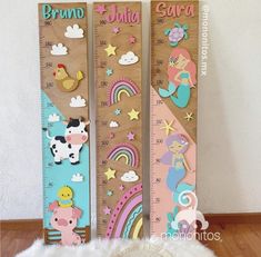 two wooden growth rulers with different designs on them